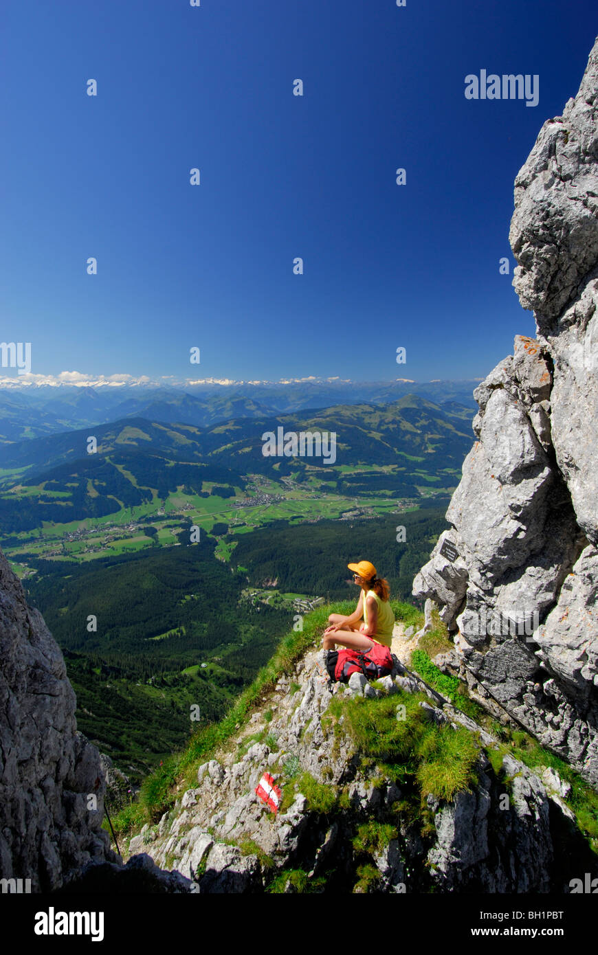 hiker at notch Kleines Toerl with view to the valley of Ellmau and Going, Hohe Tauern in background, Kaiser range, Tyrol, Austri Stock Photo