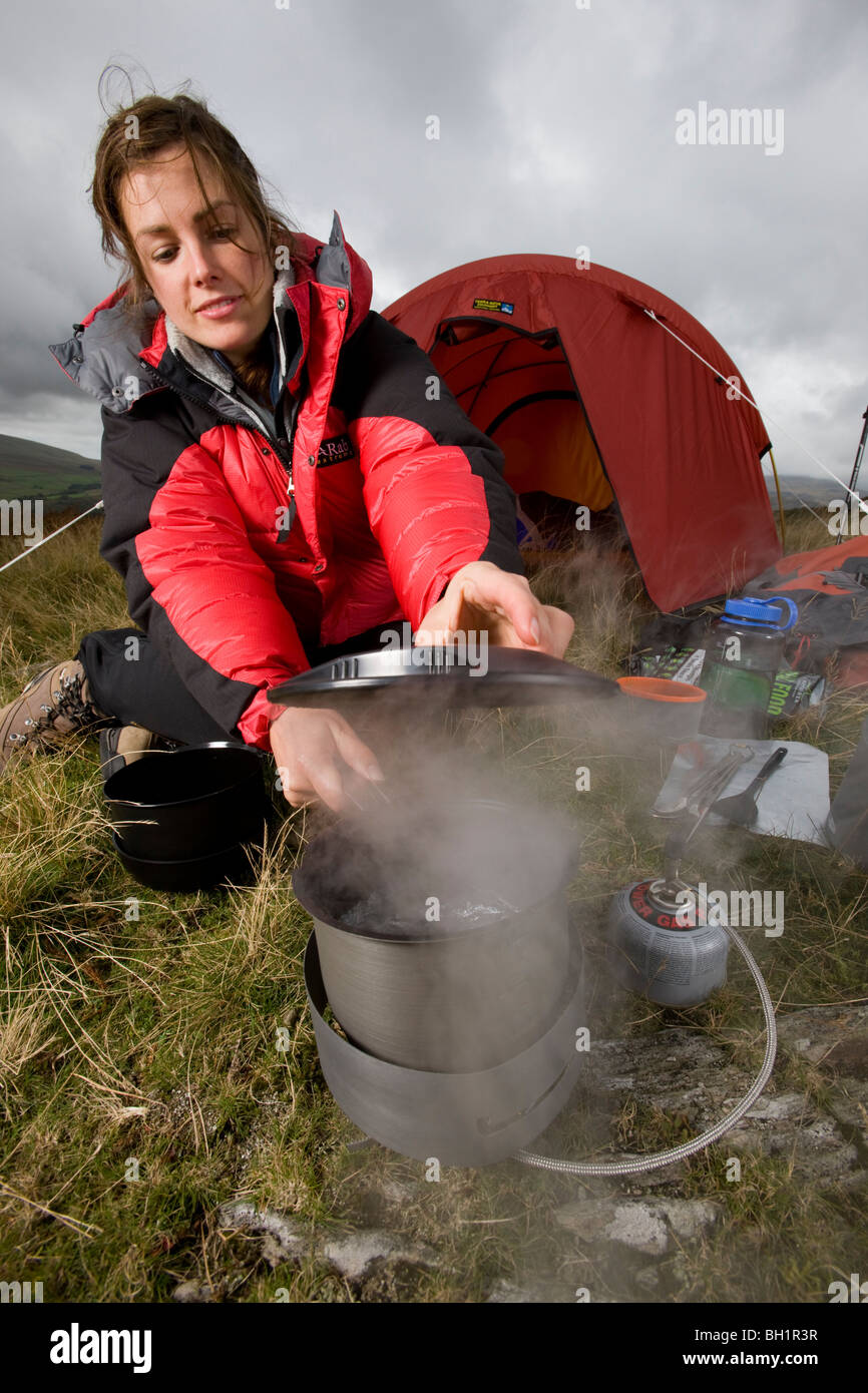 Backpacker with camp stove and tent Stock Photo