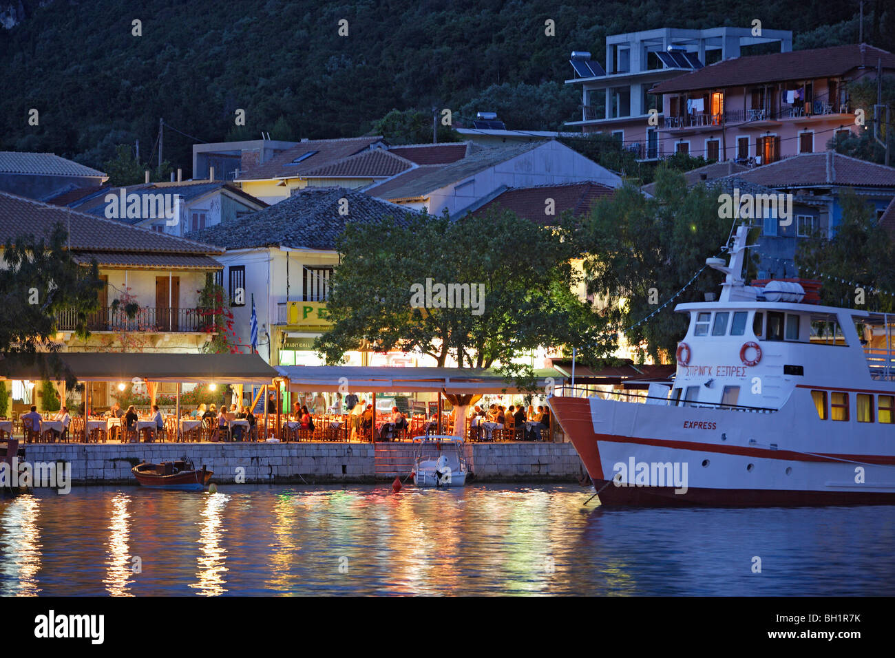 People sitting in a tavern at the harbour of Vasiliki in the evening, Lefkada, Ionische Inseln, Greece Stock Photo