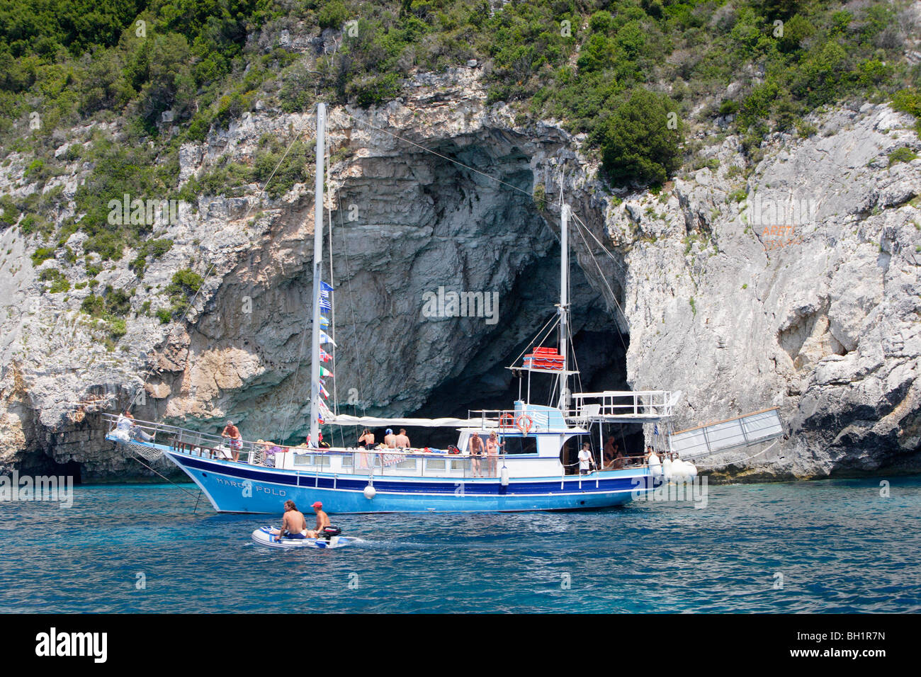 Paxos, people driving boats in front of caves on the West coast, Ionian Islands, Greece Stock Photo