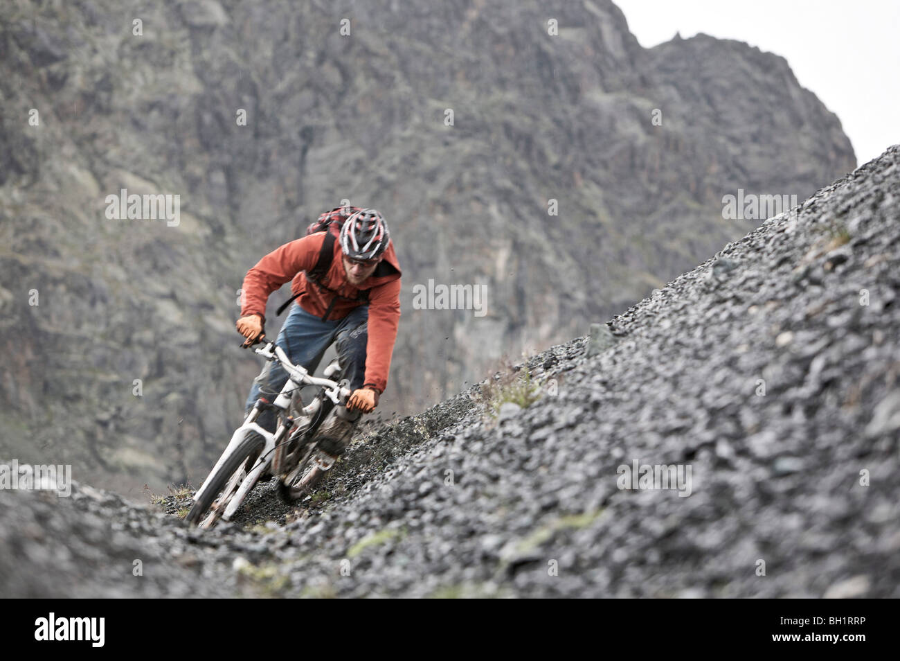 Mountainbiker riding down a scree, Ischgl, Tyrol, Austria Stock Photo