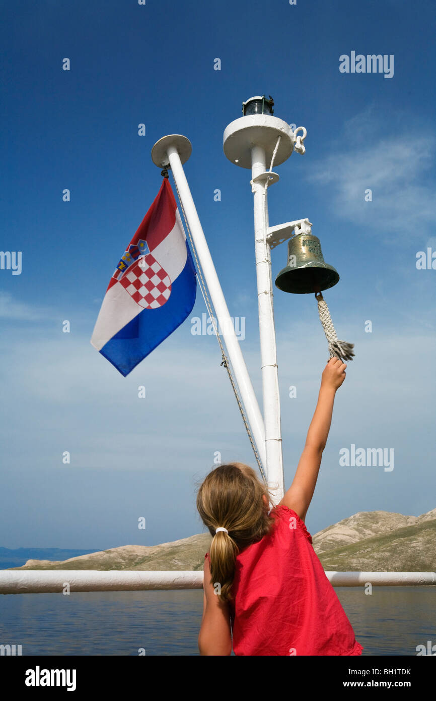 little girl ringing bell on ferryboat, croatian flag, Dalmatia, Croatia