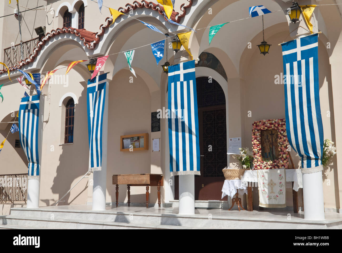 Greek flags fly outside of the Church of Ayois Kostantinos, Poros Town, Greece Stock Photo