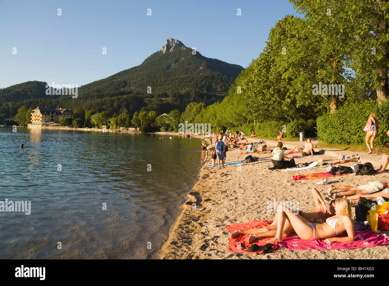 People relaxing at beach, Lake Fuschl, Fuschl am See, Salzkammergut, Salzburg, Austria Stock Photo