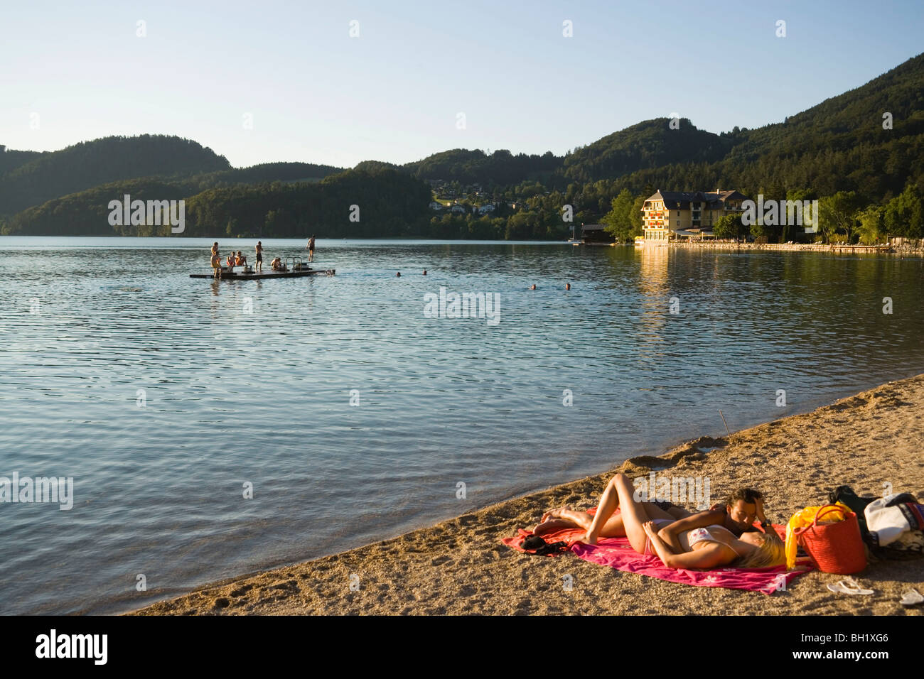 Young couple lying at beach, Lake Fuschl, Fuschl am See, Salzkammergut, Salzburg, Austria Stock Photo
