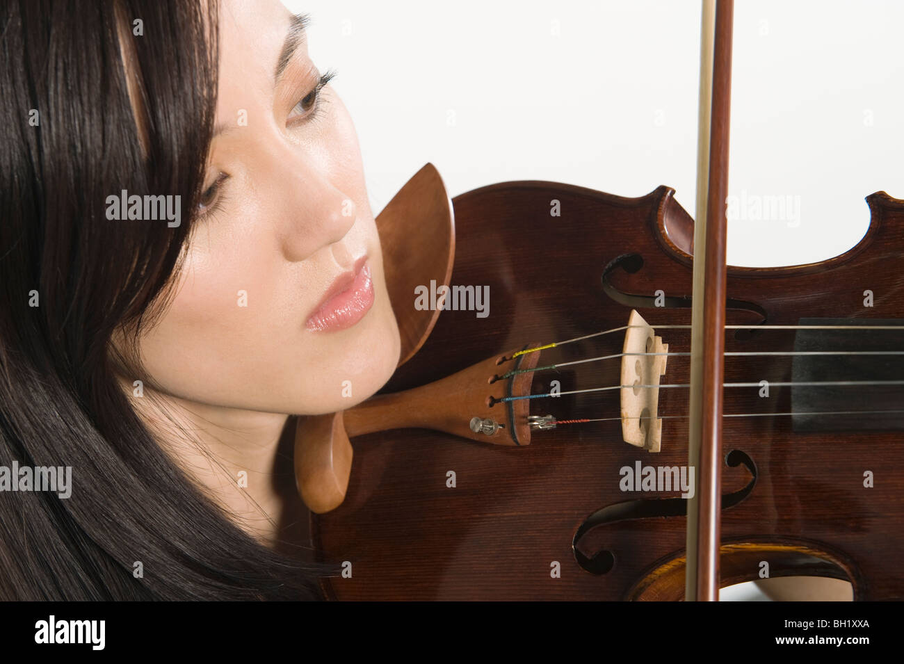Young Asian woman concentrates on playing the violin Stock Photo - Alamy