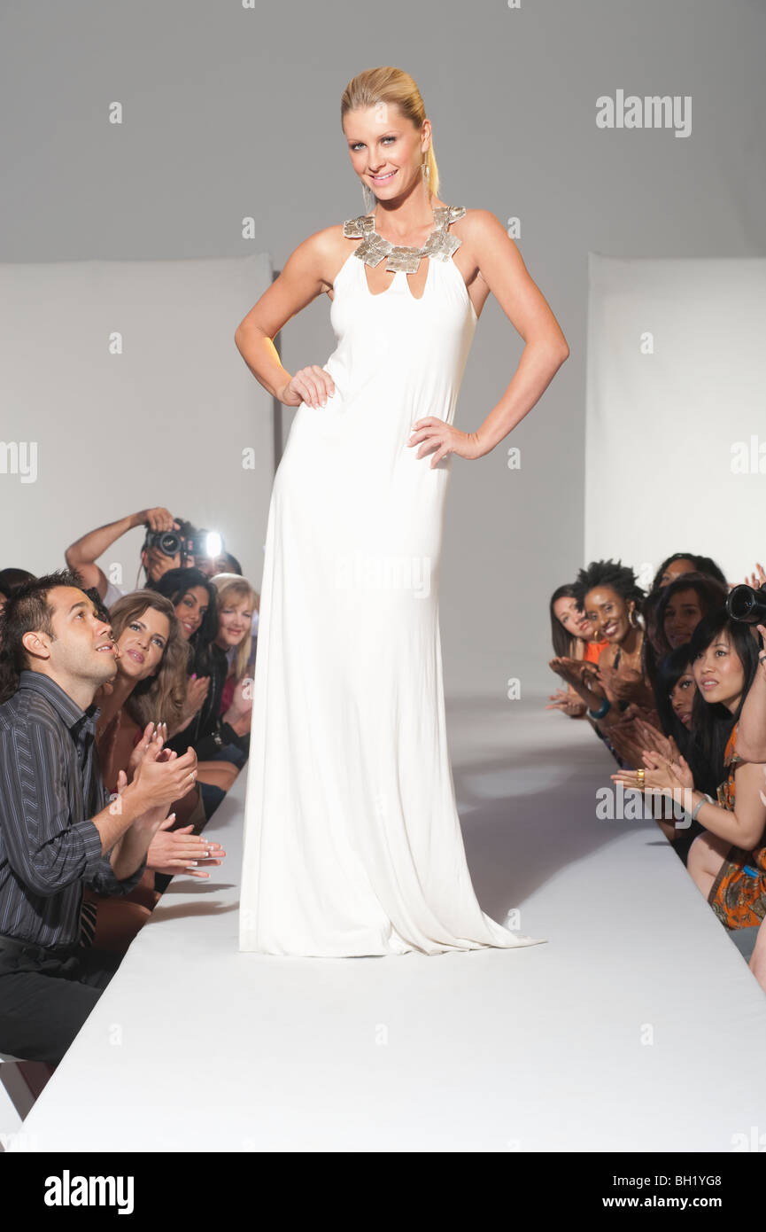 Woman stands in bridalwear on fashion catwalk Stock Photo
