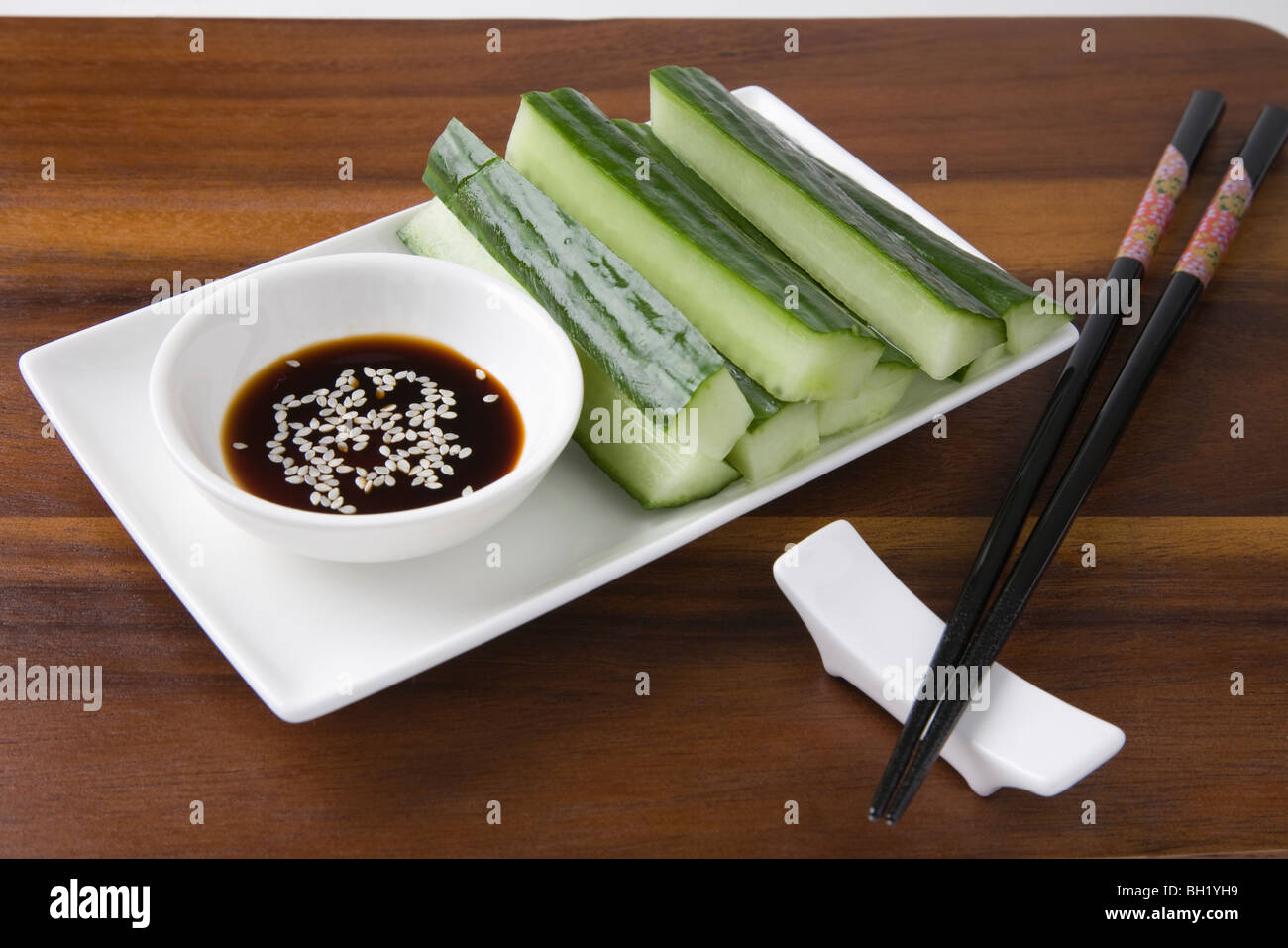 Soy sauce, cucumber and sesame seeds with chopsticks Stock Photo