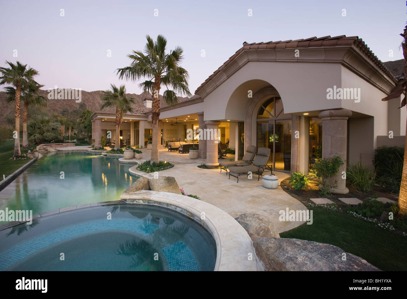 Luxury swimming pool and house exterior at dusk Stock Photo