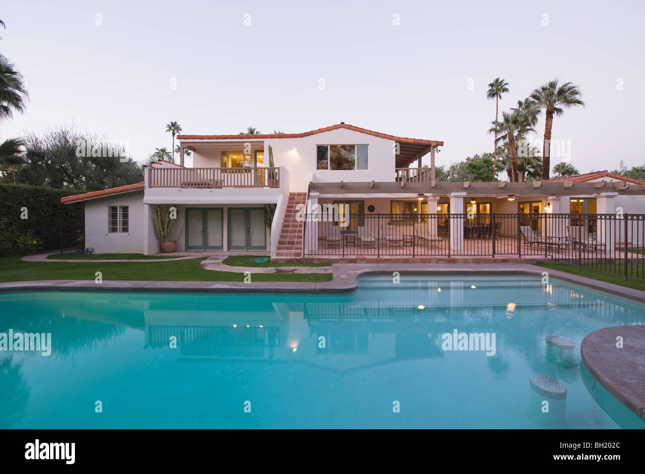 Swimming pool and lit exterior of Palm Springs home exterior Stock Photo