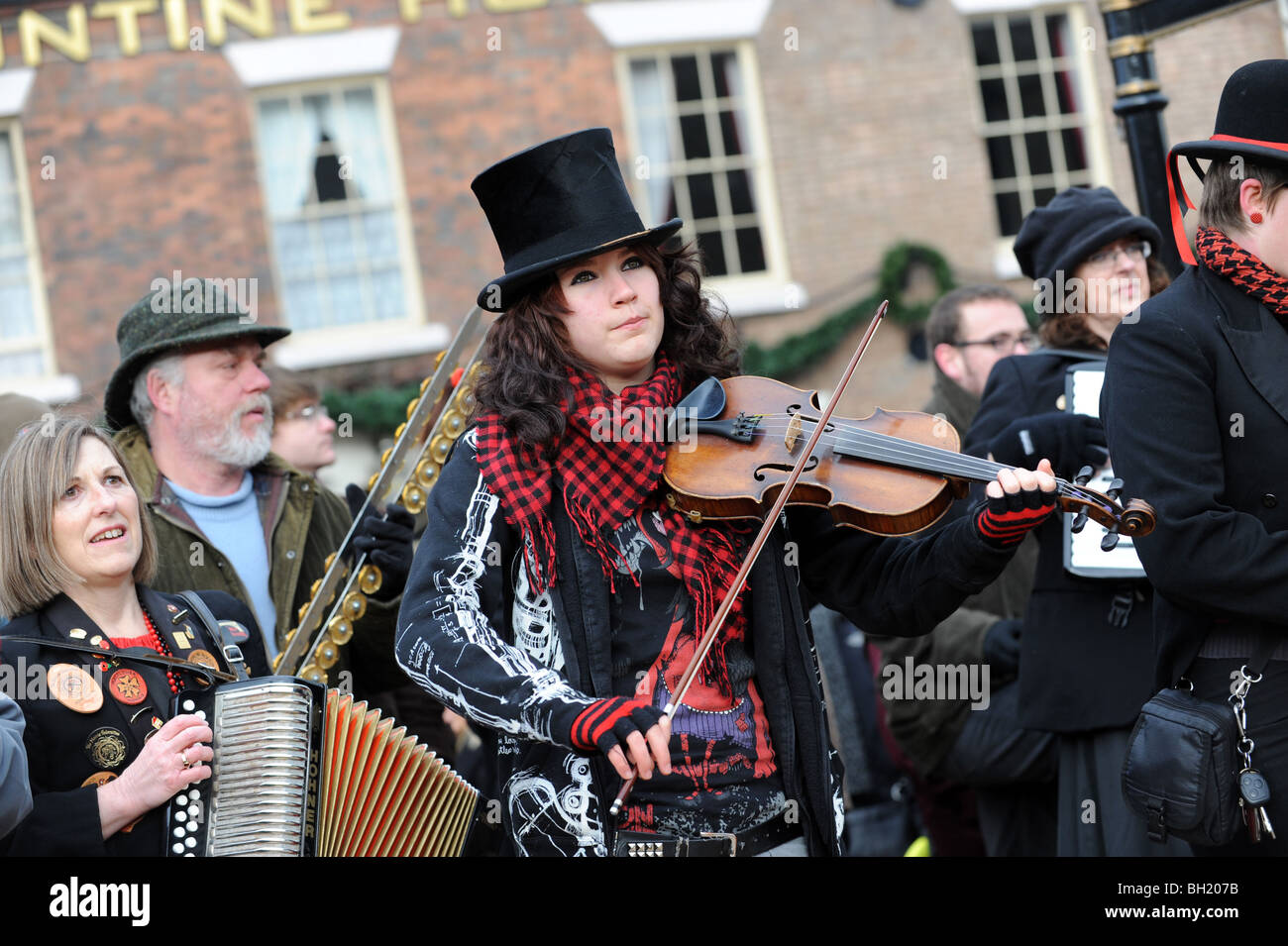 Female violinist with The Ironmen and Severn Gilders morris dancers performing on the Ironbridge on New Years Day Stock Photo
