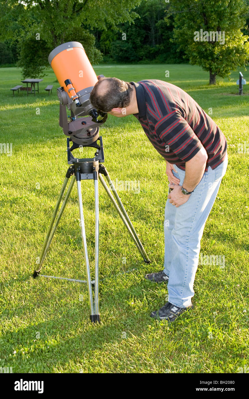 A man looking through a telescope Stock Photo Alamy