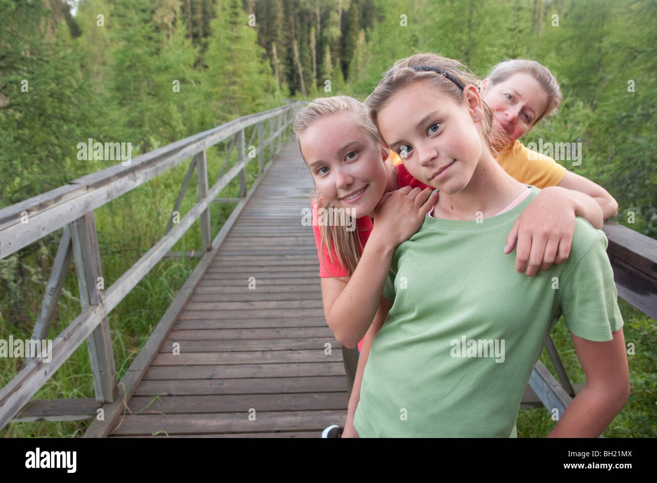Three women posed on boardwalk nature trail, Riding Mountain National Park, Manitoba, Canada Stock Photo