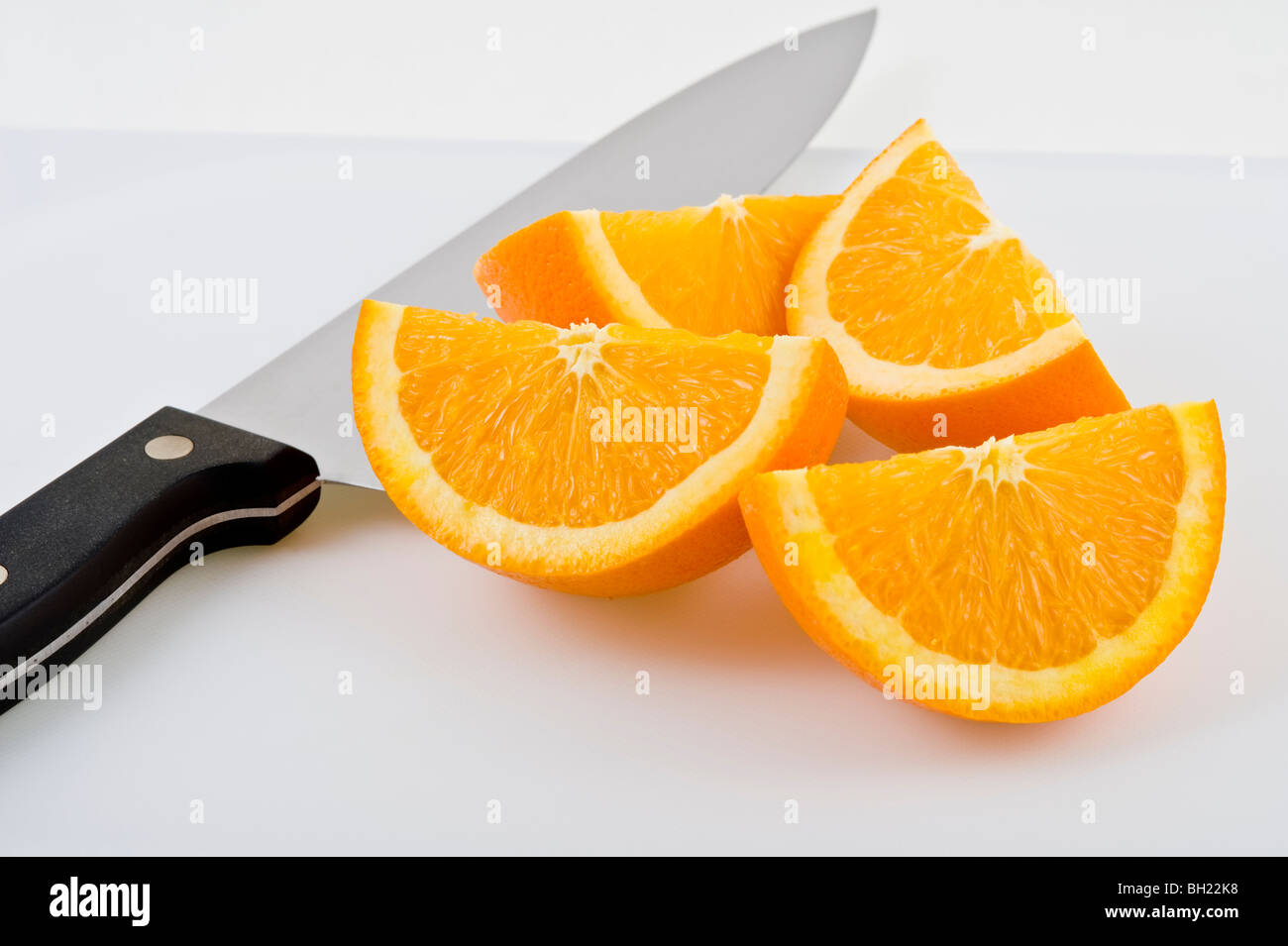 orange quarters and knife on white background Stock Photo Alamy