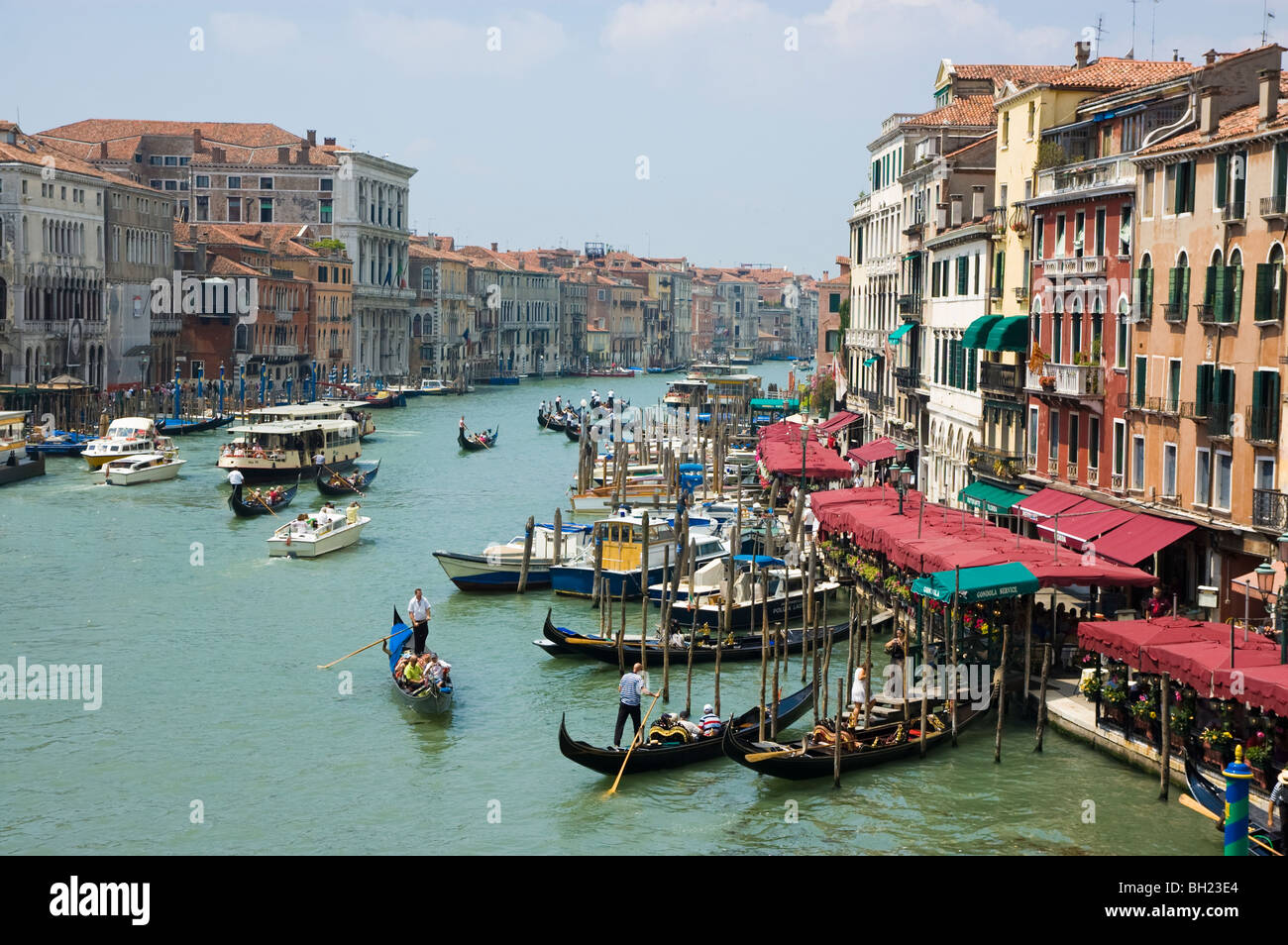 A beautiful summer day in Venice. A shot from the Rialto Bridge. The canal is busy with gondolas and water taxis. Stock Photo