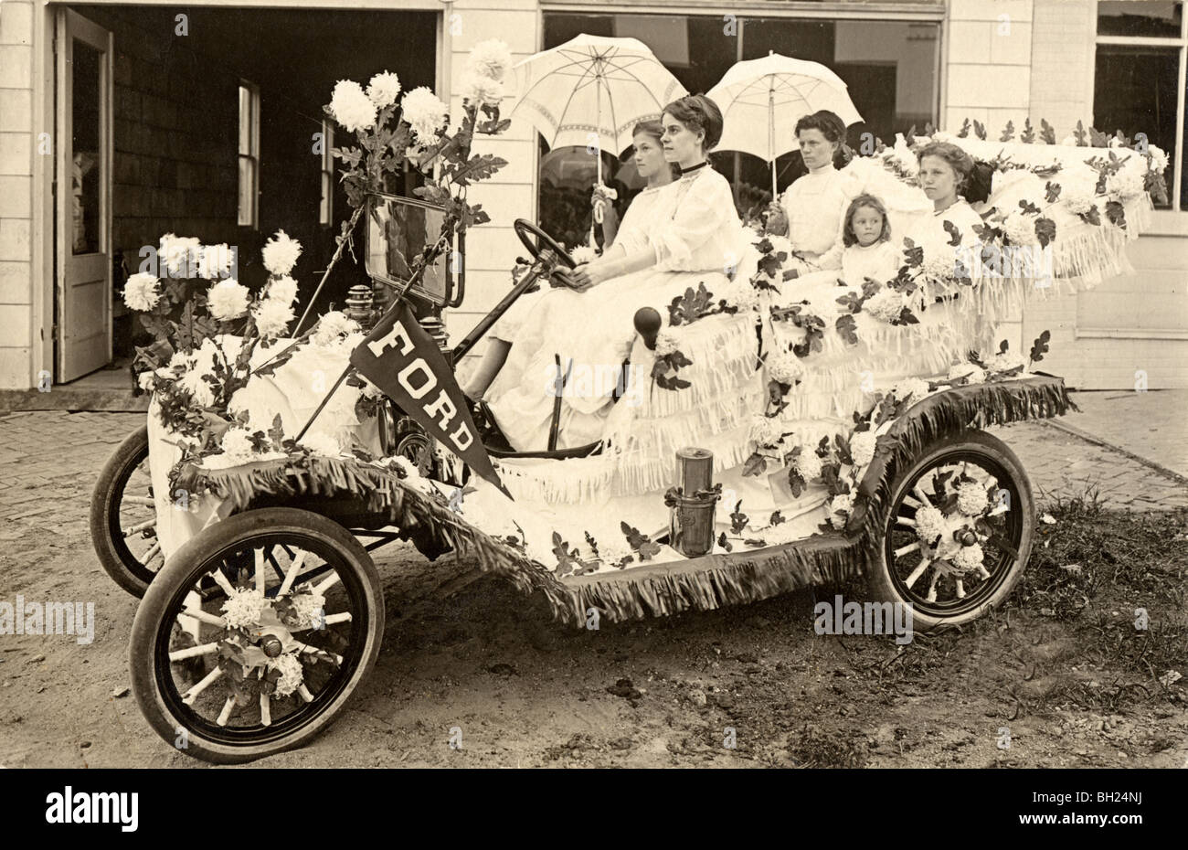 Girls Driving Floral Decorated Model T Ford Parade Car Stock Photo