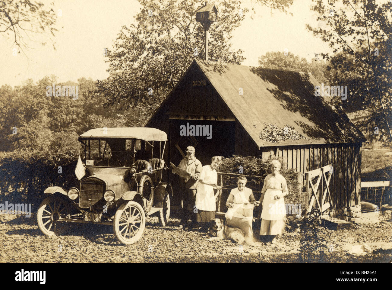 Family with Model A Ford at Garage Barn Stock Photo