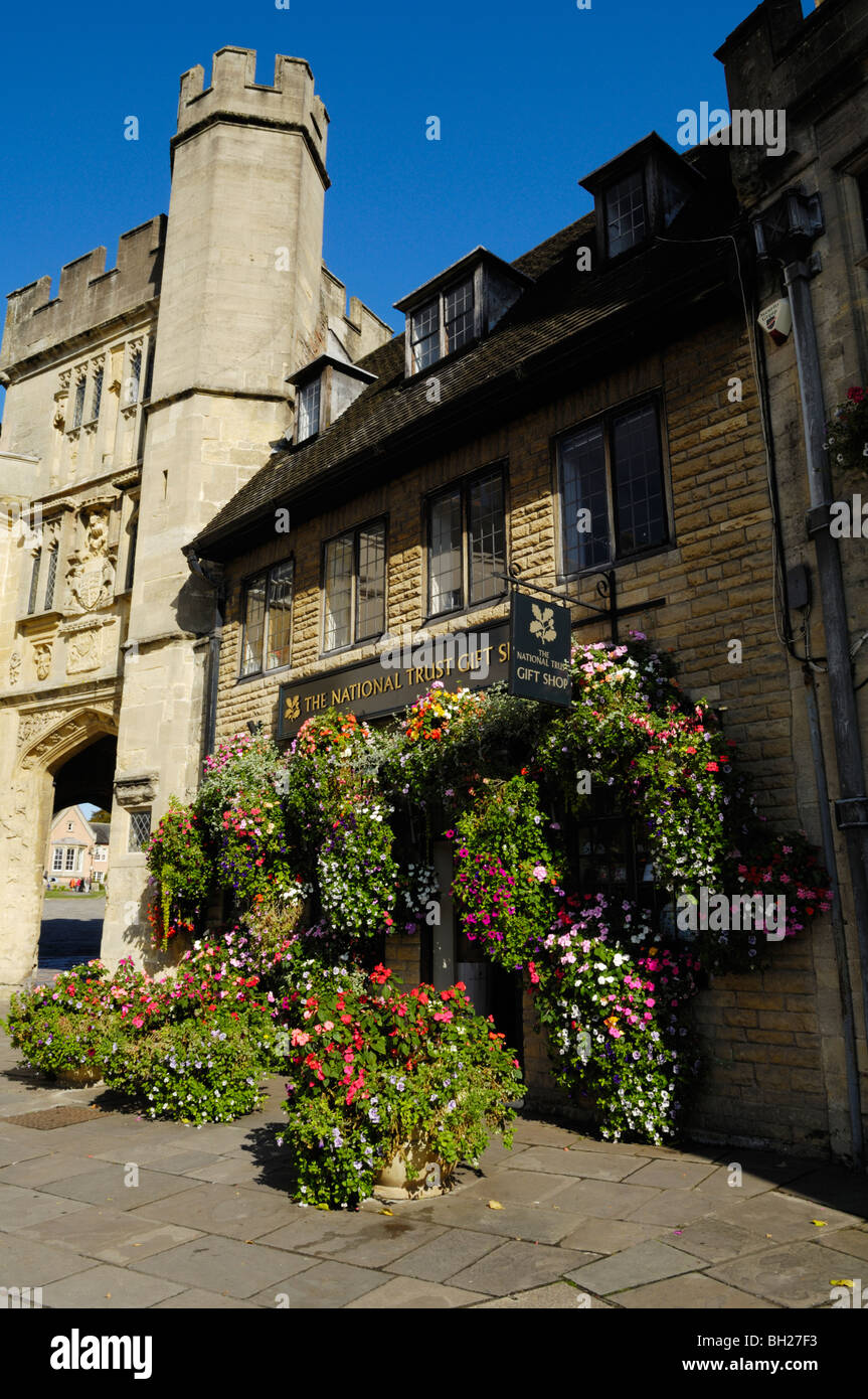 A floral display outside the National Trust gift shop by Penniless Porch in the Market Place, Wells, Somerset, England Stock Photo