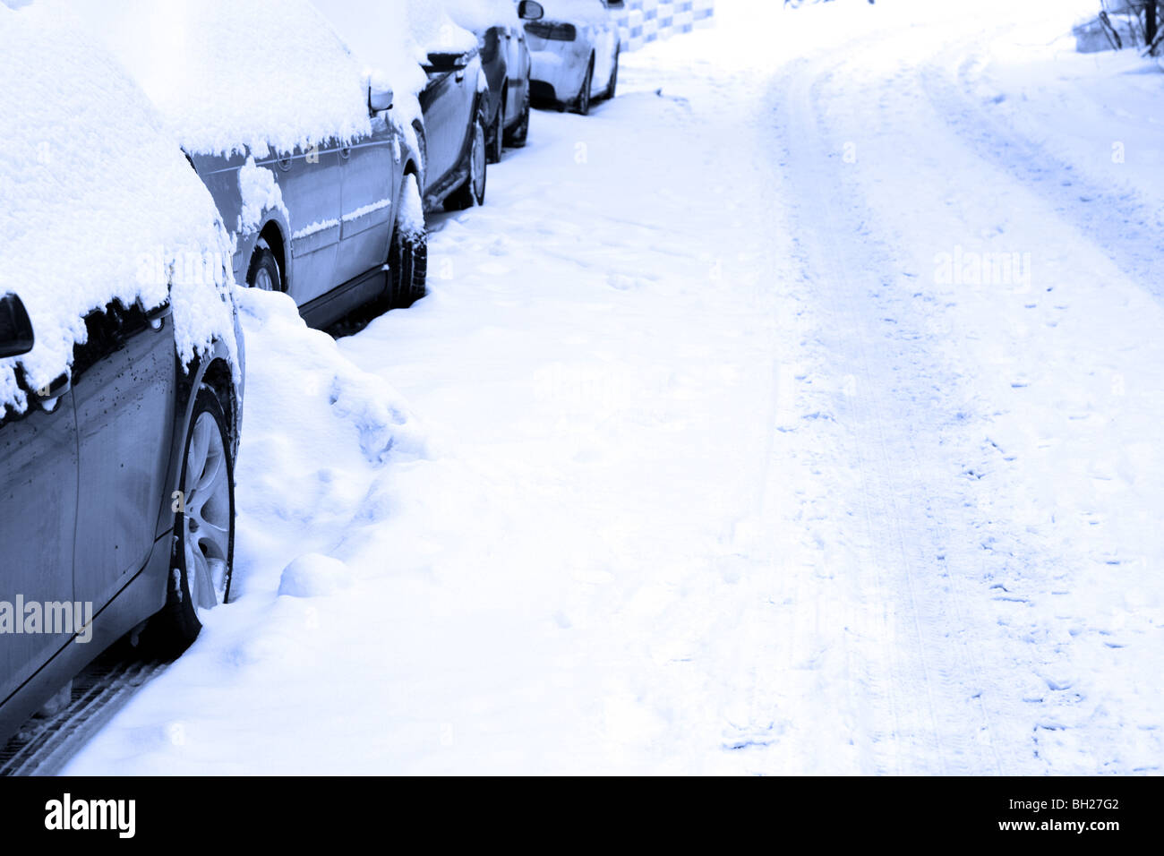 Several cars parking on a snowbound street. Stock Photo