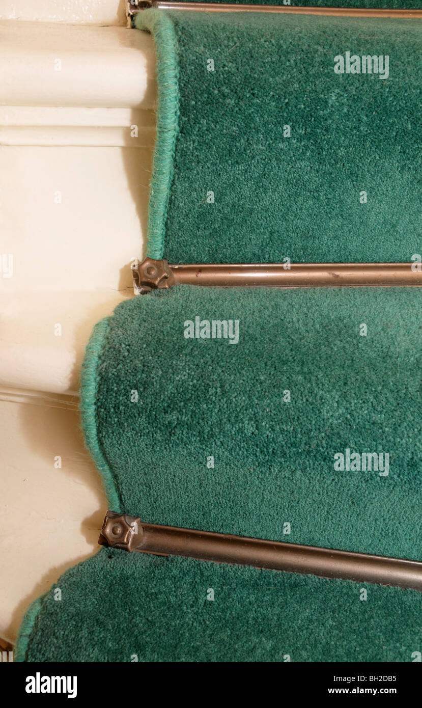 Closeup of carpet rods on a carpeted stairway. Stock Photo