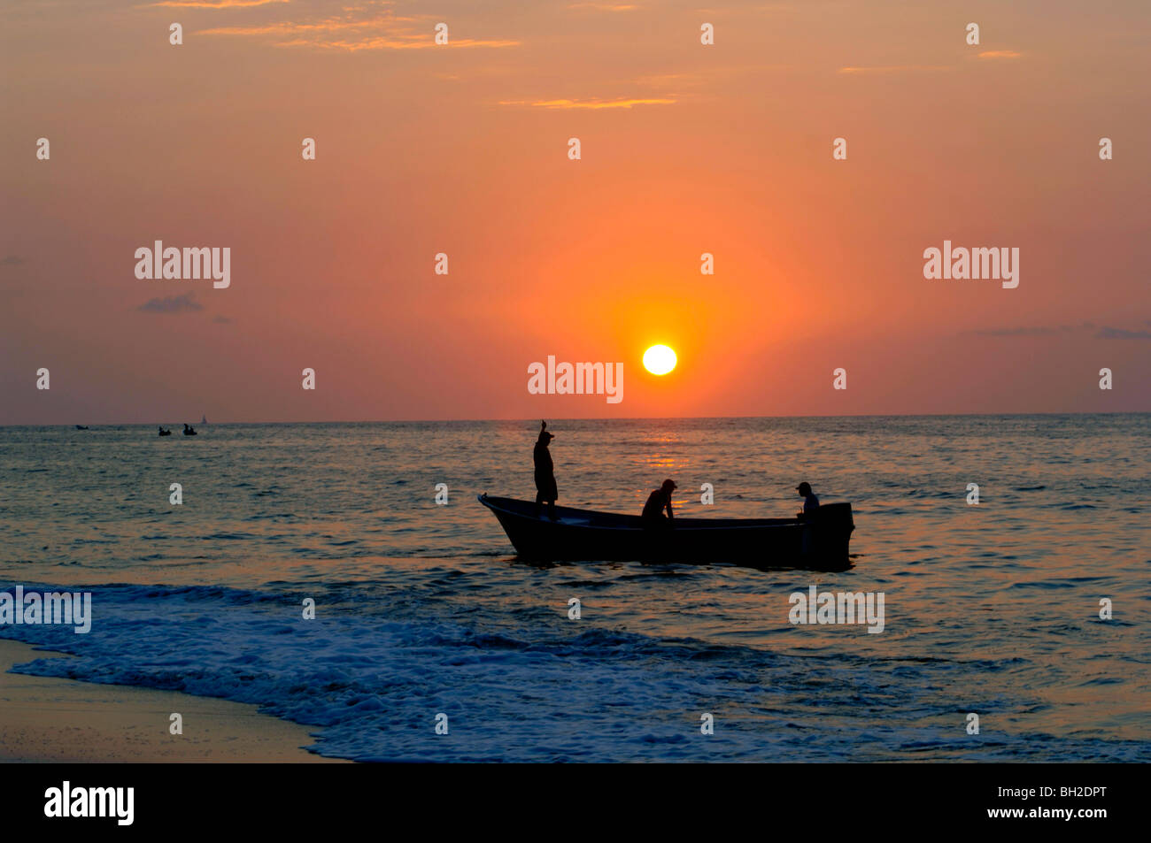 Golden orange sunset with reflections and fishing boat hi-res stock ...