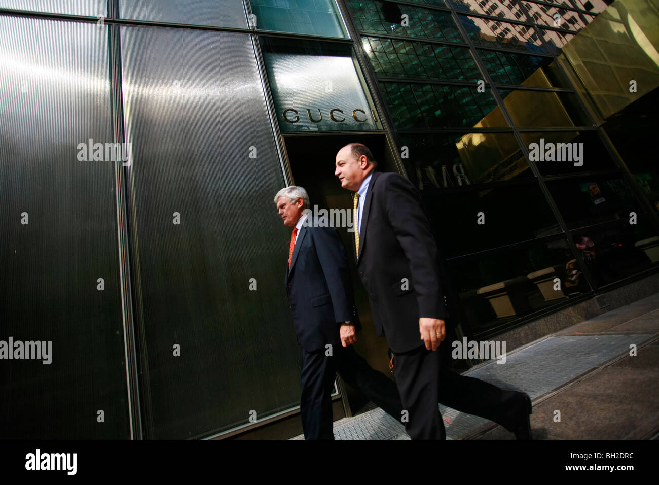 Business men walking by the Gucci store on the 5th Avenue Stock Photo