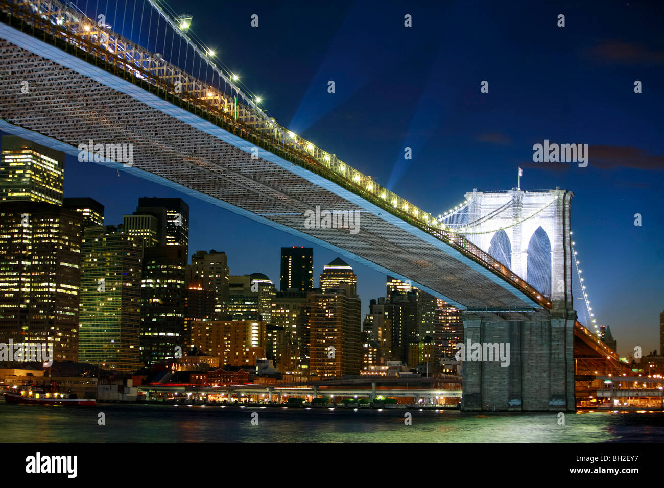 View of the Brooklyn Bridge Night and Days where people walk or ride across the East river to Manhattan Stock Photo