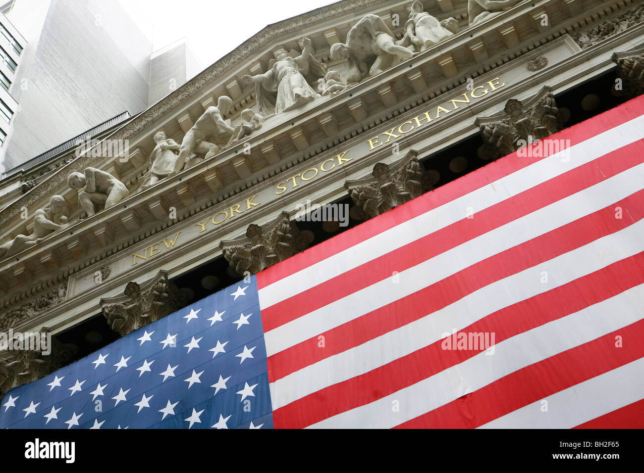 Wall Street and the New York Stock Exchange in New York with a huge American flag Stock Photo