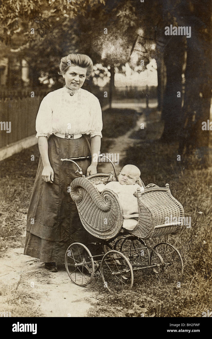 Pretty Young Mother & Infant in Wicker Baby Carriage Stock Photo