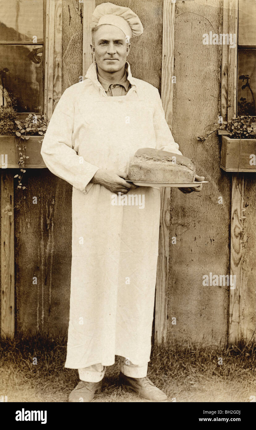Baker in Baker's Hat Carrying Loaf of Bread Stock Photo Alamy