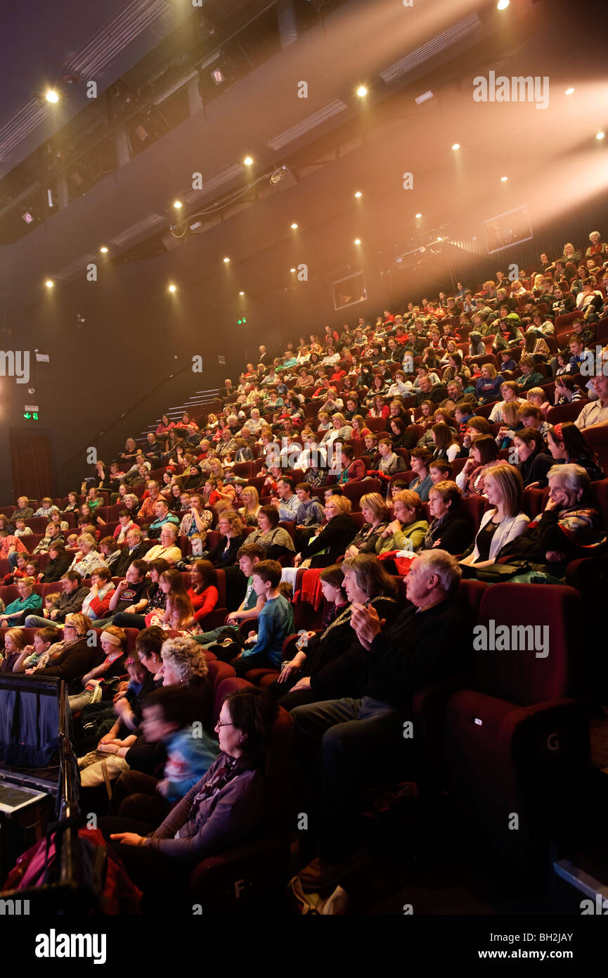 A full theatre audience sitting in auditorium watching a play