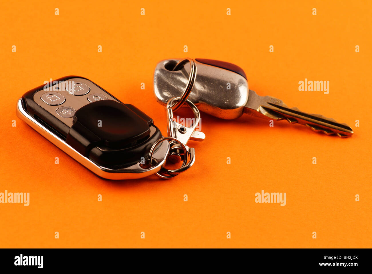 Close-up of a car alarm remote control and car keys on an orange background Stock Photo