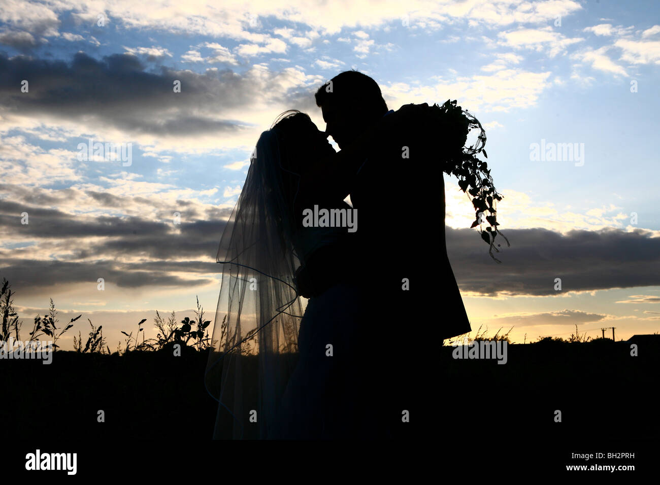 Silhouette of bride and groom against a dramatic sky Stock Photo - Alamy