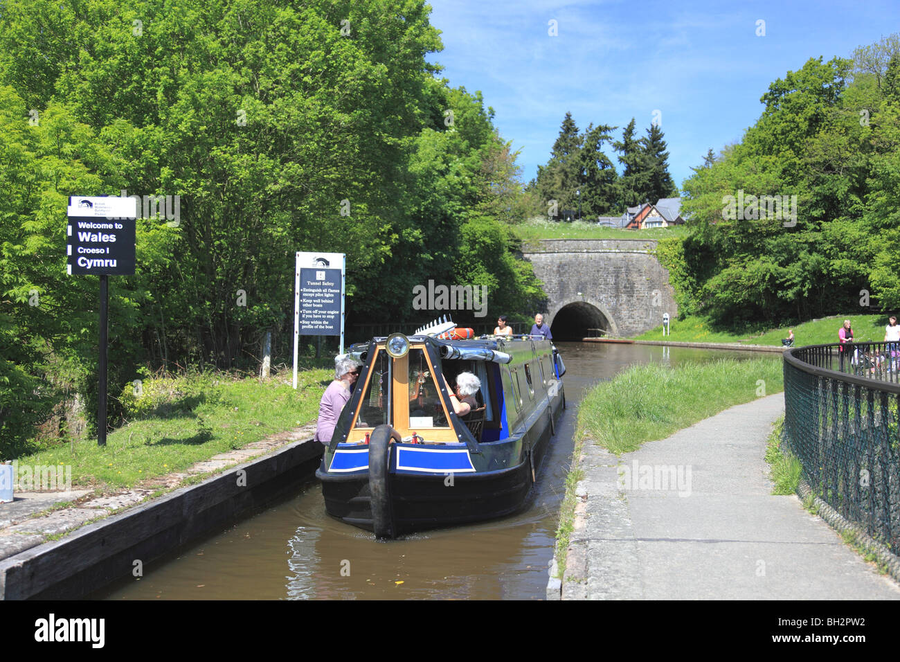A narrowboat coming from Chirk Tunnel on to Chirk Aqueduct where the Llangollen Canal crosses the English/Welsh border Stock Photo