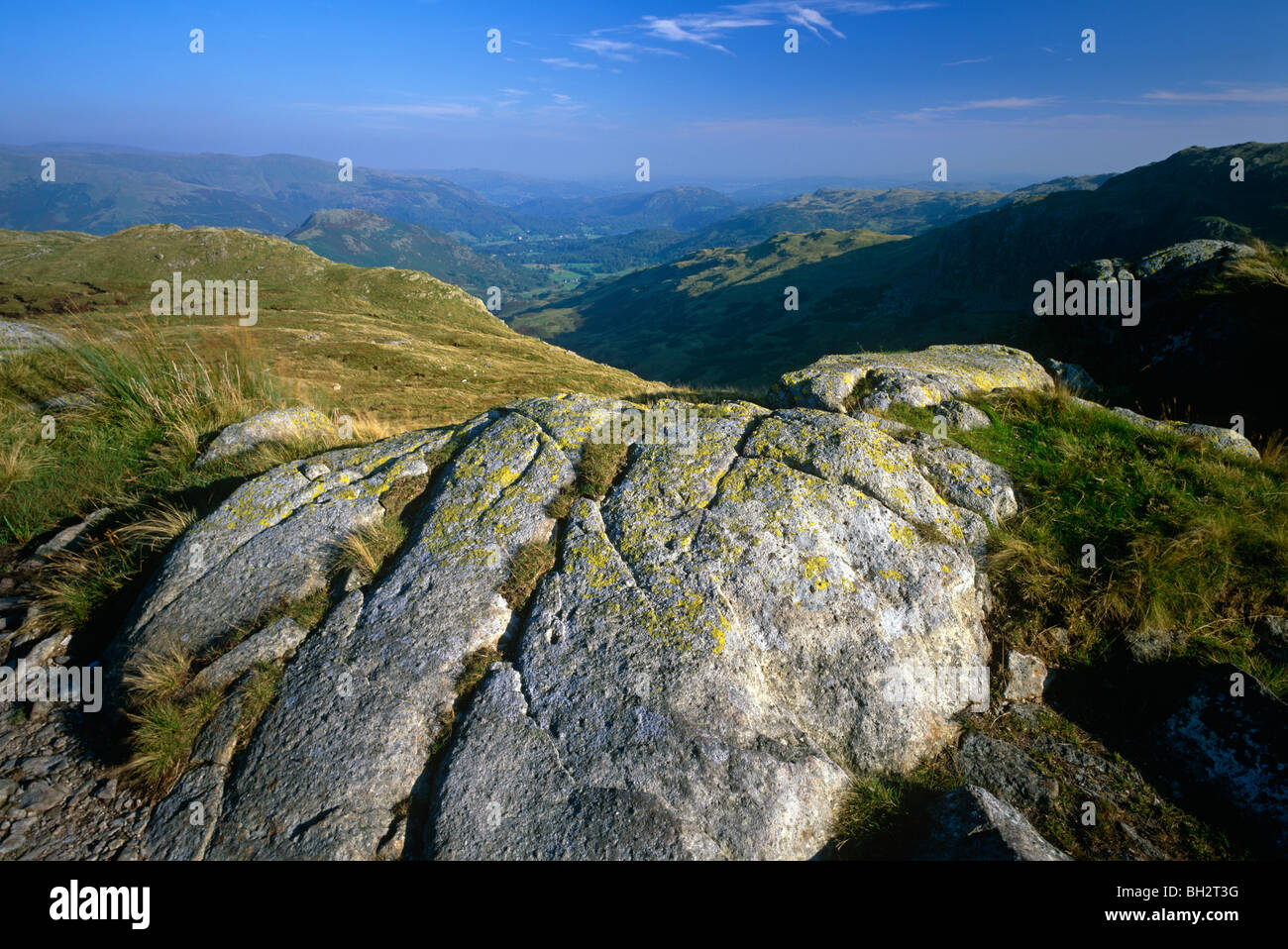 A view in summer in the Lake District National Park looking towards Helm Crag and Grasmere Village from Grasmere Common Stock Photo