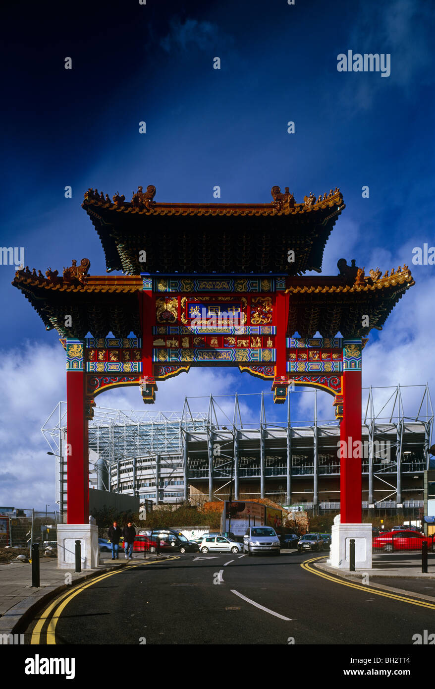 The Chinatown arch at the entrance to Stowell Street, Chinatown, Newcastle upon Tyne - with St James' Park in the background Stock Photo