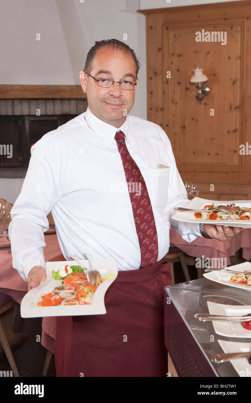 Restaurant waiter carrying plates food hires stock photography and