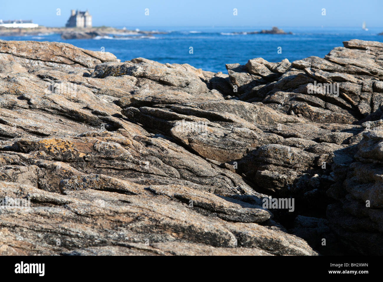 Cote Sauvage rocks with Turpault Mansion on the bacground, Quiberon, departament de Morbihan, Brittany, France Stock Photo