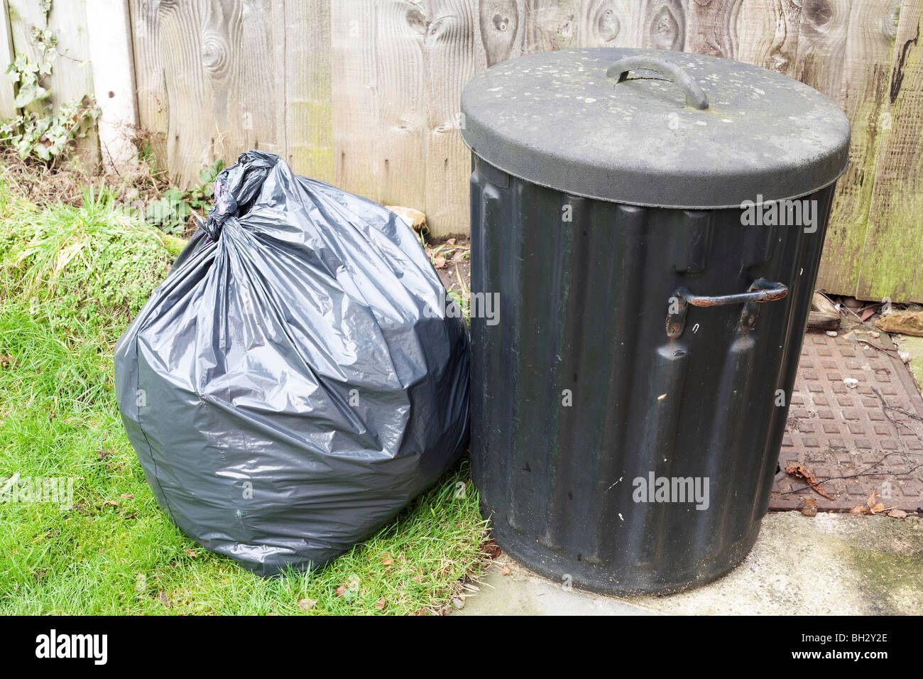 black rubber trash can with rubbish bag waiting collection Stock Photo