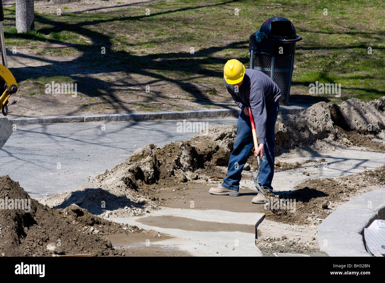 Construction worker with hardhat using a shovel. Stock Photo
