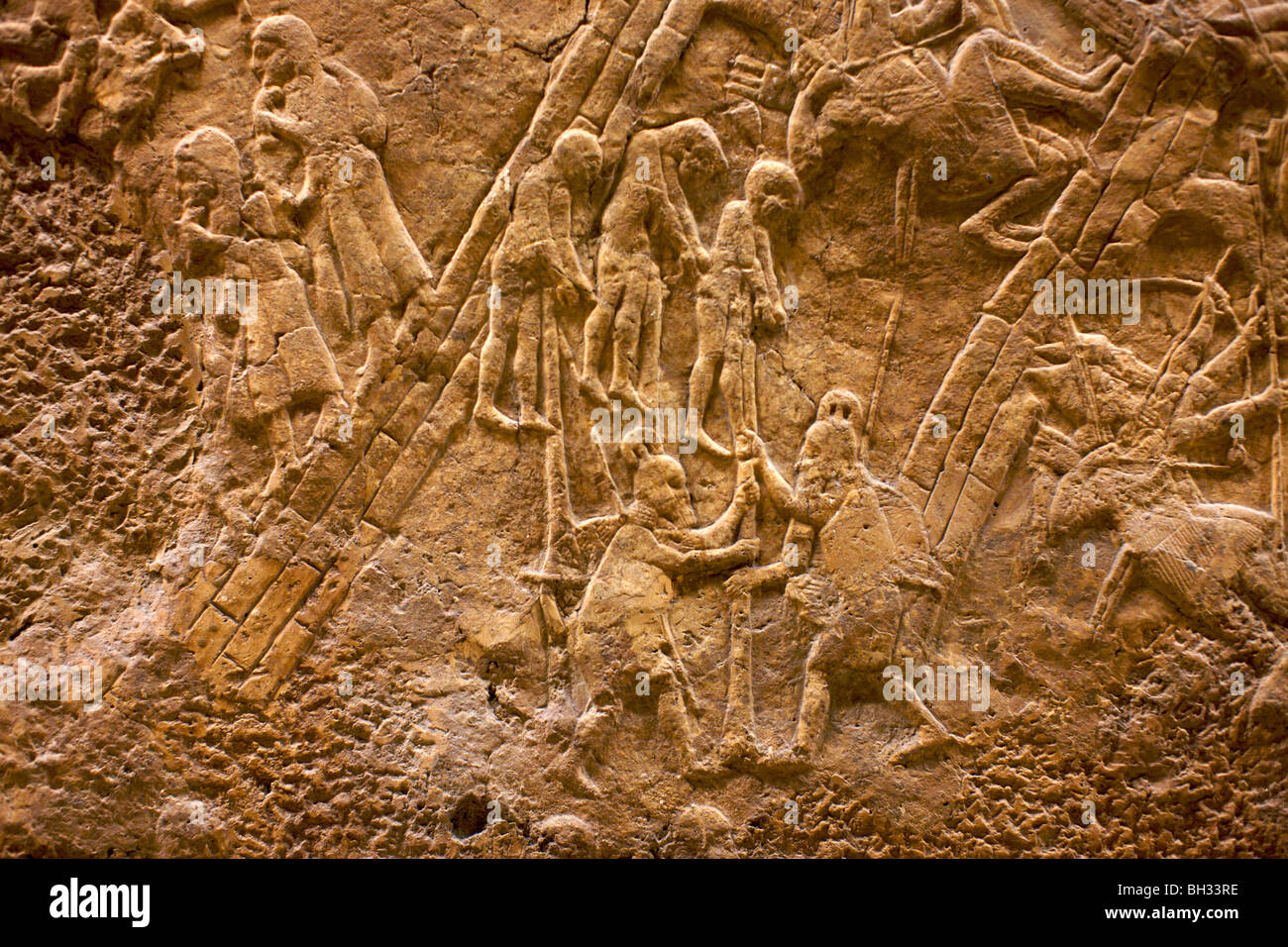 Prisoners being impaled on stakes in a detail of an Assyrian frieze now in the British Museum London Stock Photo
