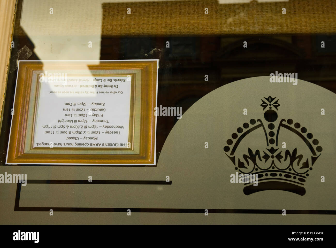 Opening hours sign upside down in pub window Birmingham England UK Europe Stock Photo