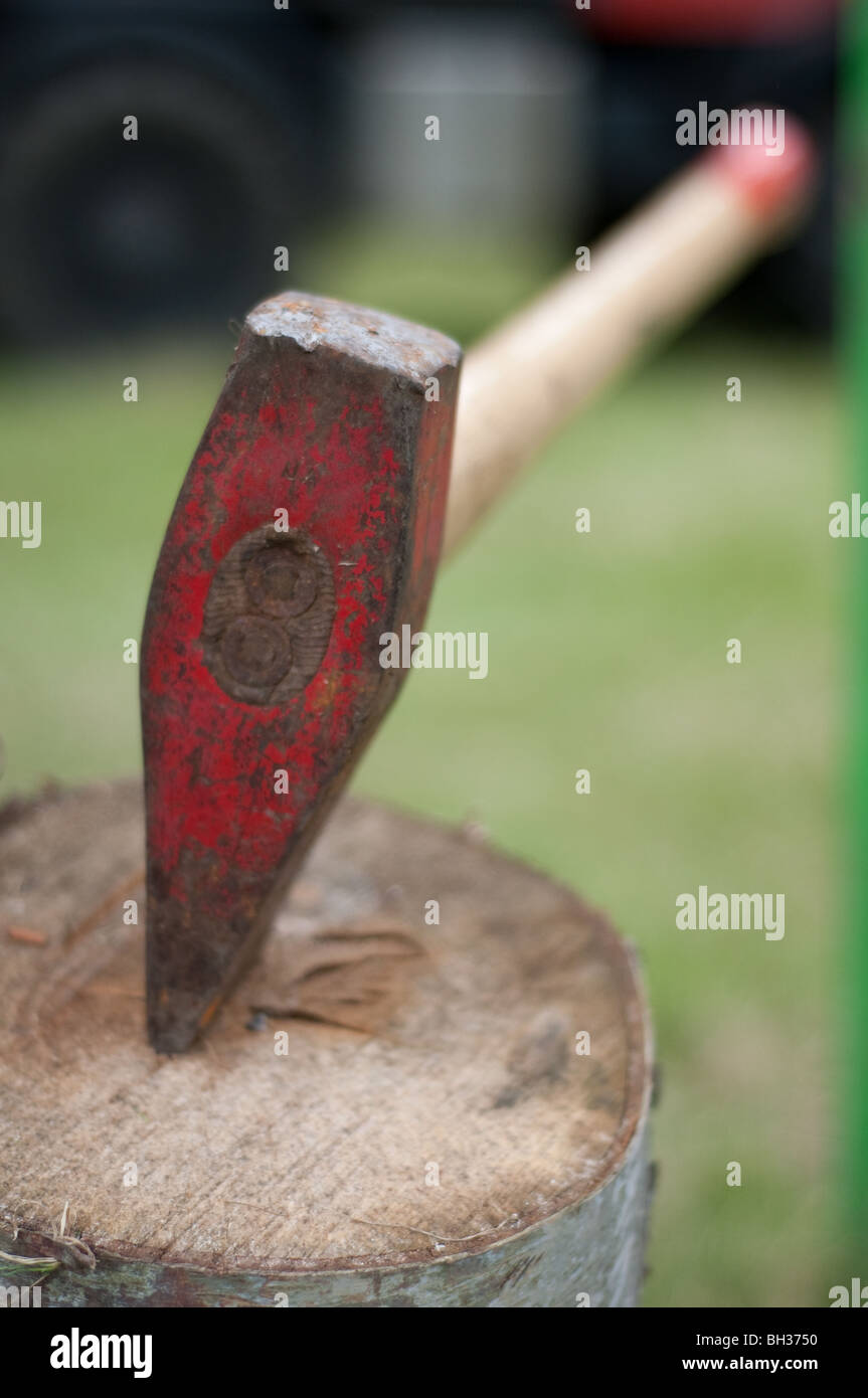 A splitting axe or maul in a log Stock Photo