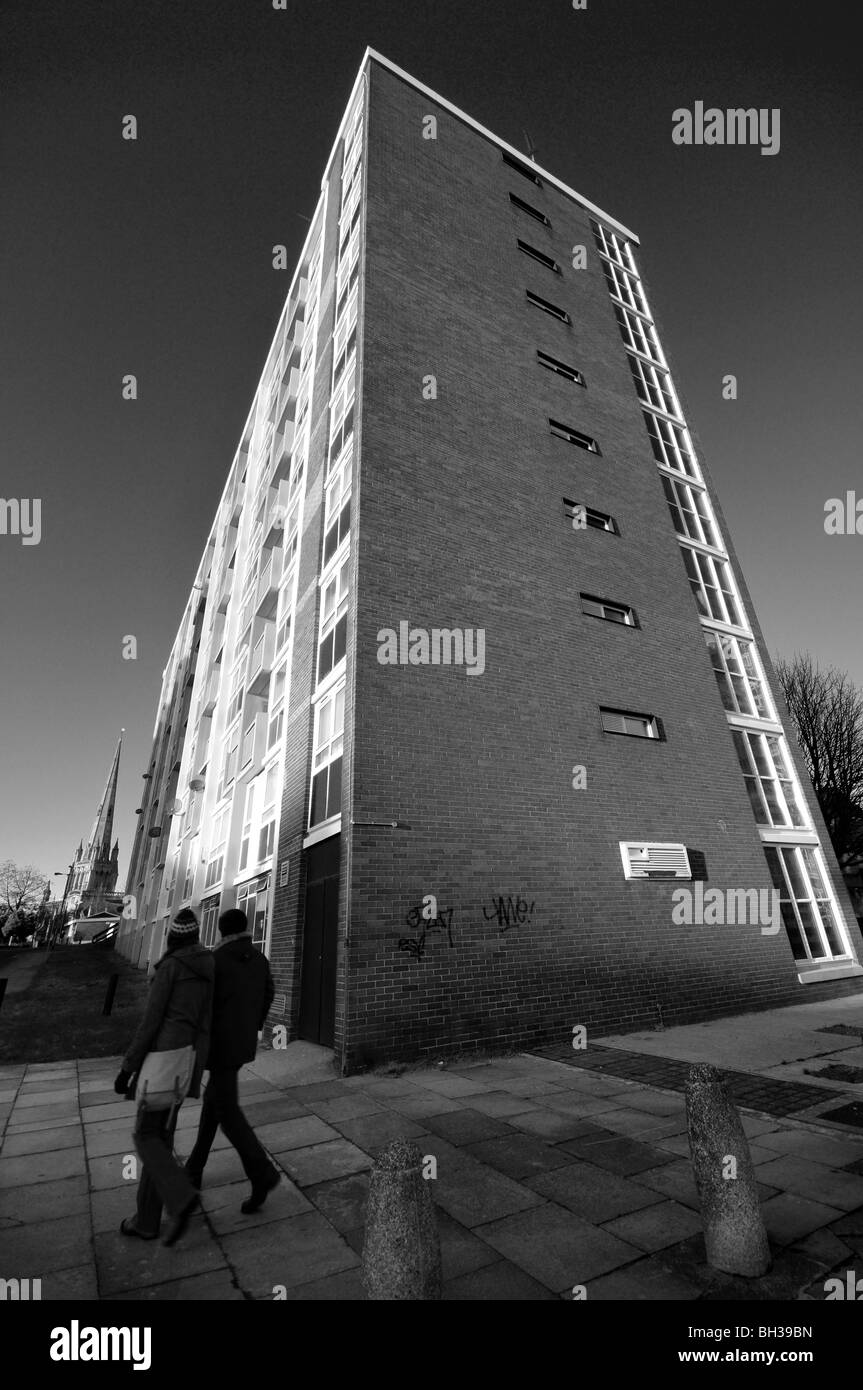 Monotone picture of  Bristol City Council estate block of flats on a winter cold sunny day with 2 residents walking past. Stock Photo