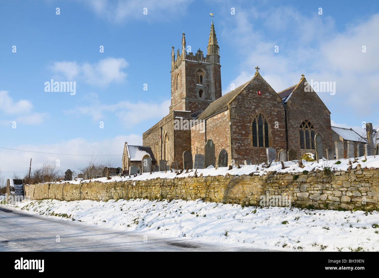View of Somerset country parish church above a road with snow on the ground Stock Photo