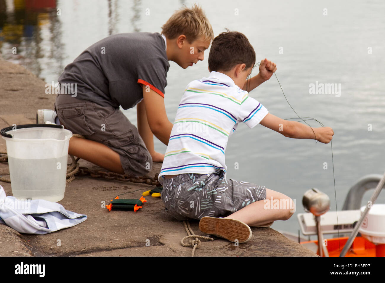 Wells-Next-The-Sea, two boys fishing for crabs.... Stock Photo