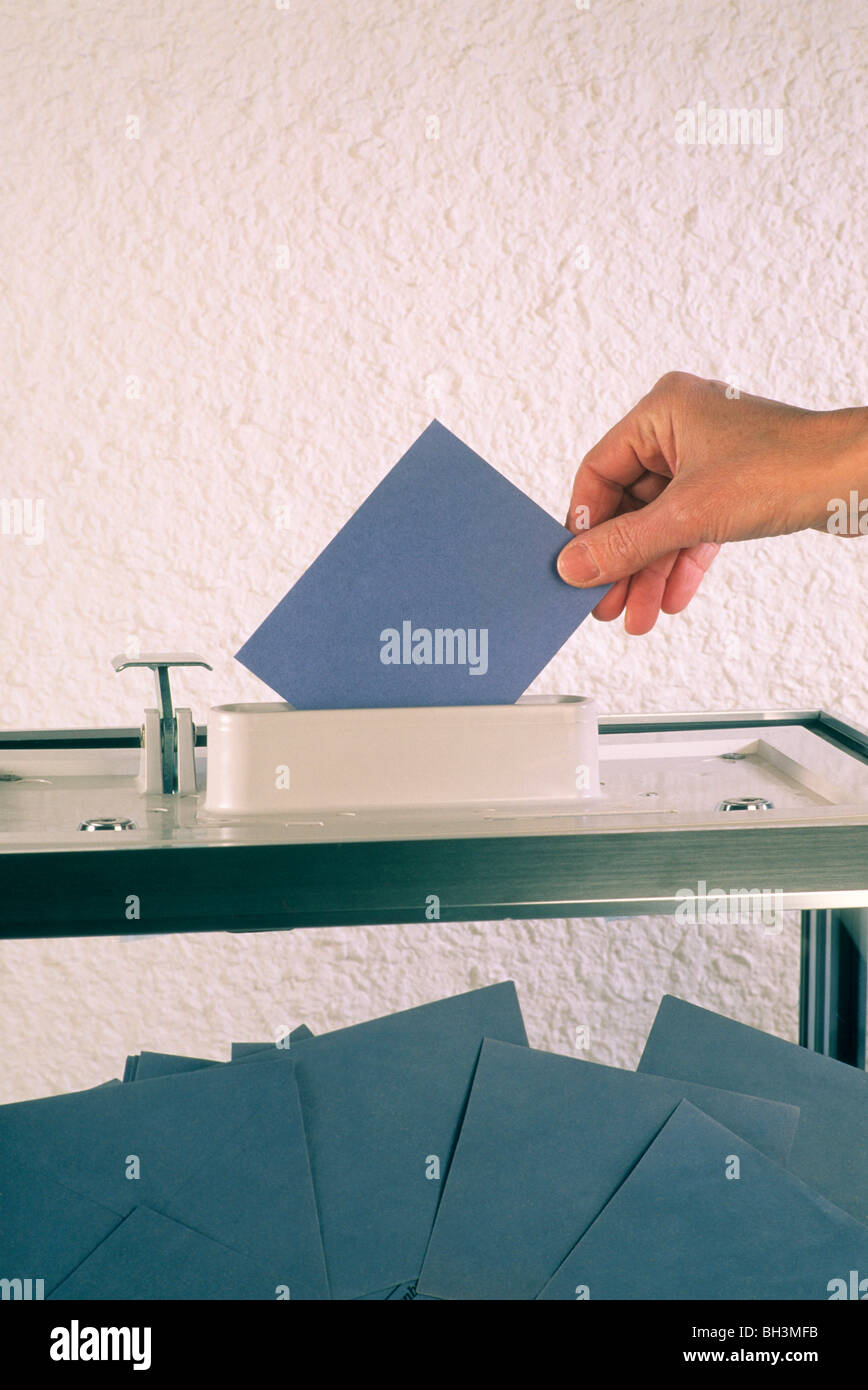 Hand putting a vote into a ballot box. Stock Photo