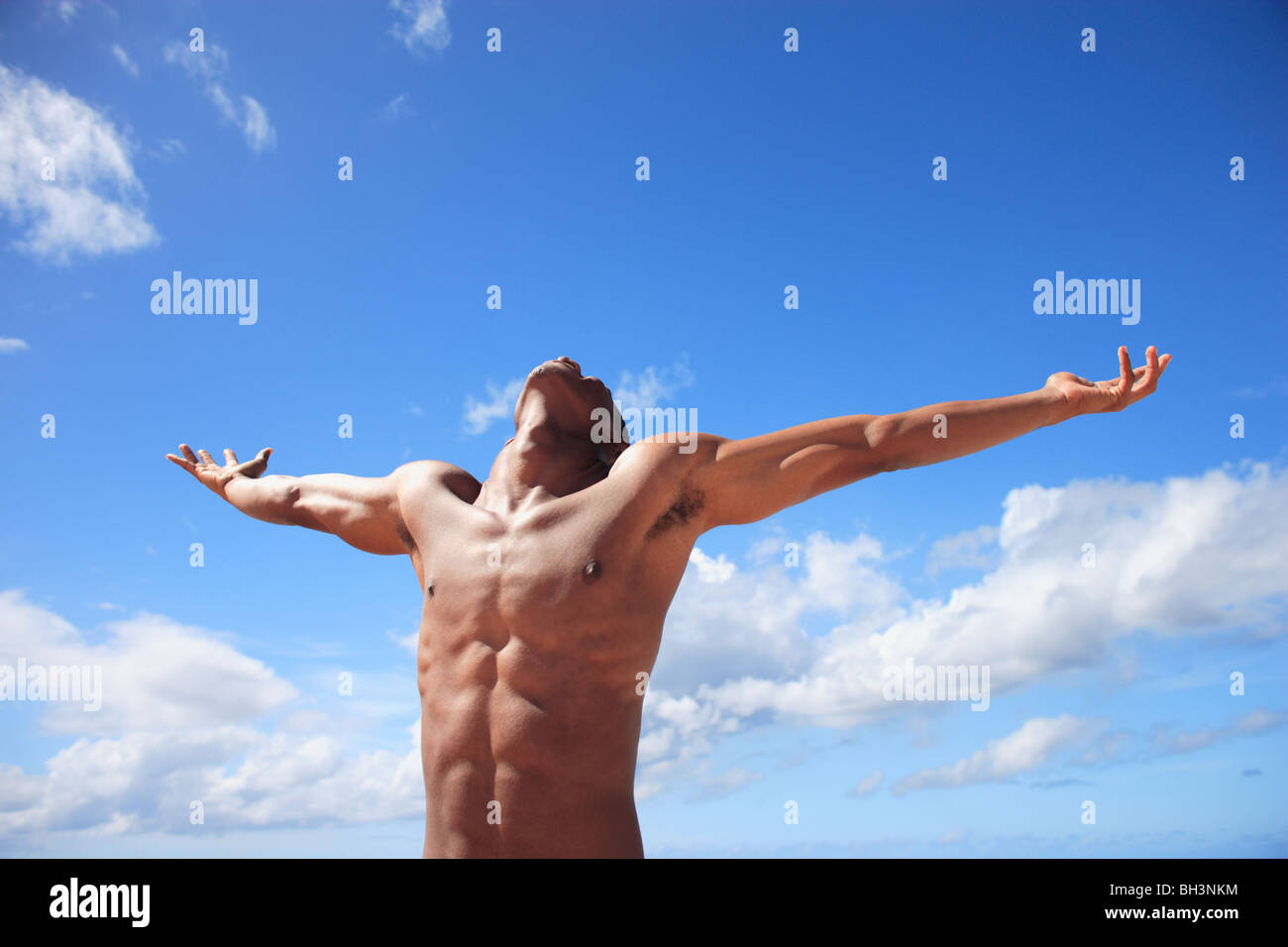Young man with his arms outstretched towards the sky Stock Photo