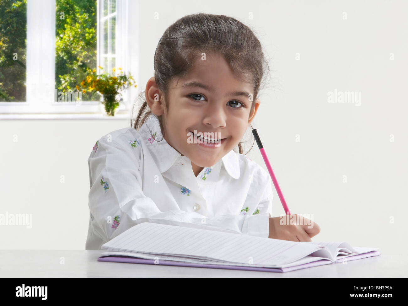 Girl with a book and pencil Stock Photo - Alamy