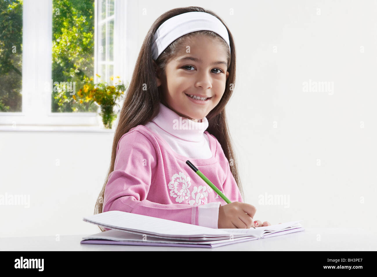 Girl with a book and pencil Stock Photo - Alamy